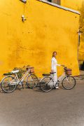 Frau mit weißem Fahrrad mit vor gelber Wand ©pexels / anna tarazevic